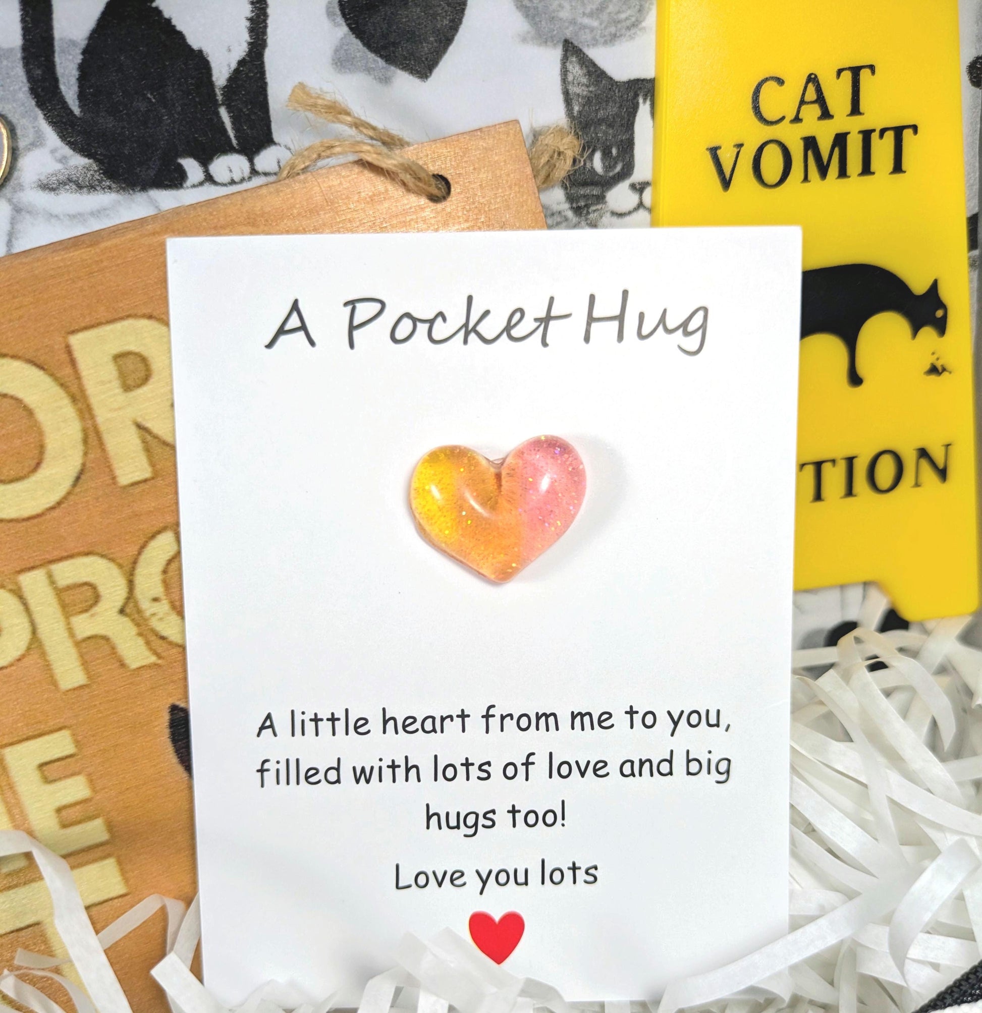 Personalised gift card with glass heart and printed message, accompanied by cat-themed wooden and yellow signs.