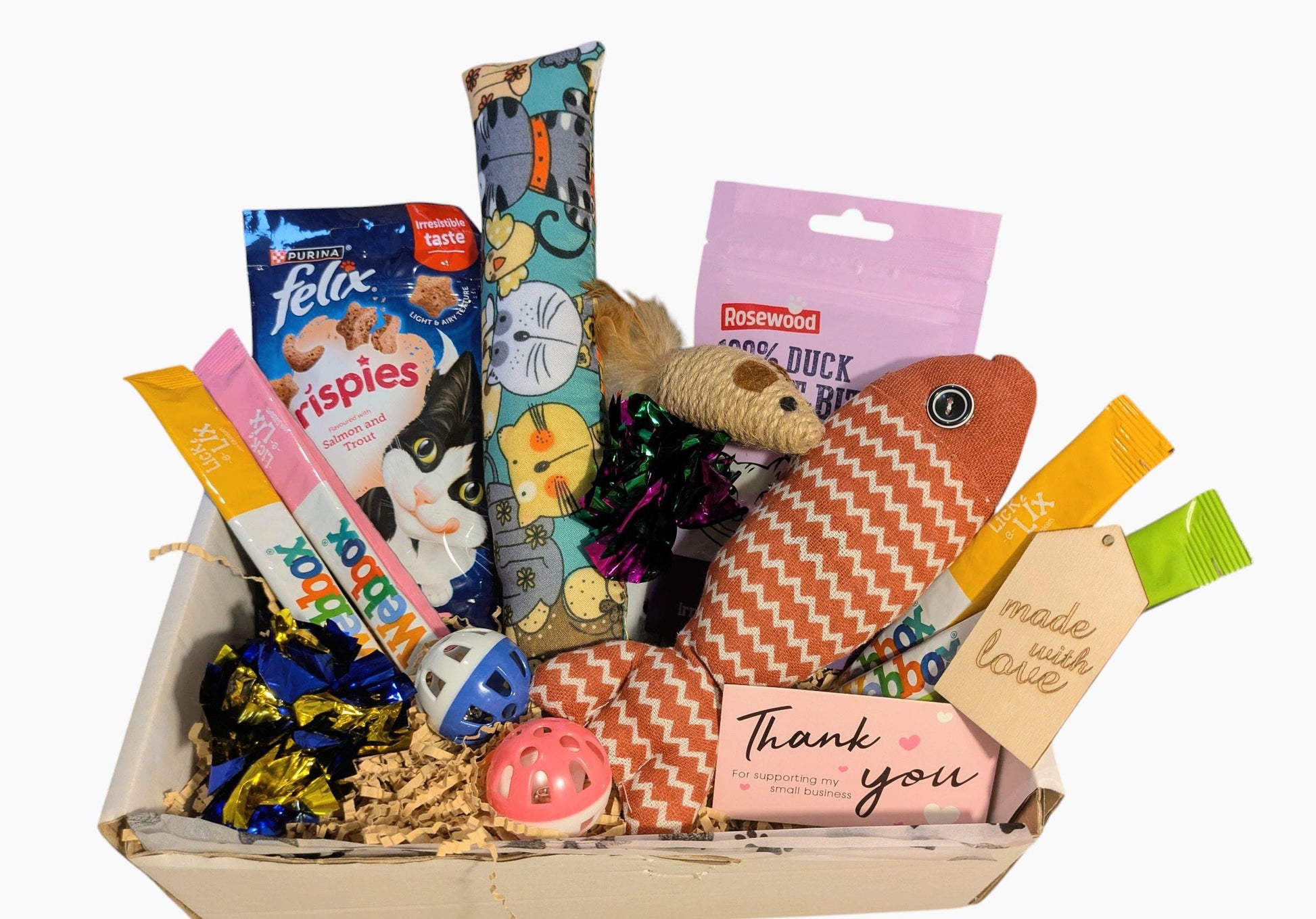 Large beige cat treat box with assorted toys including fish-shaped catnip pillow, mouse toy, plush ball, and packets of cat.