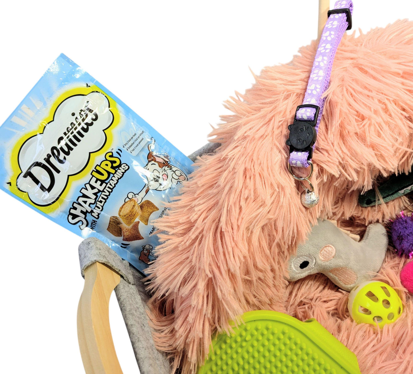 Luxury personalised cat gift box featuring a fluffy pink bed, a patterned purple collar, catnip toys, treats, and a green.