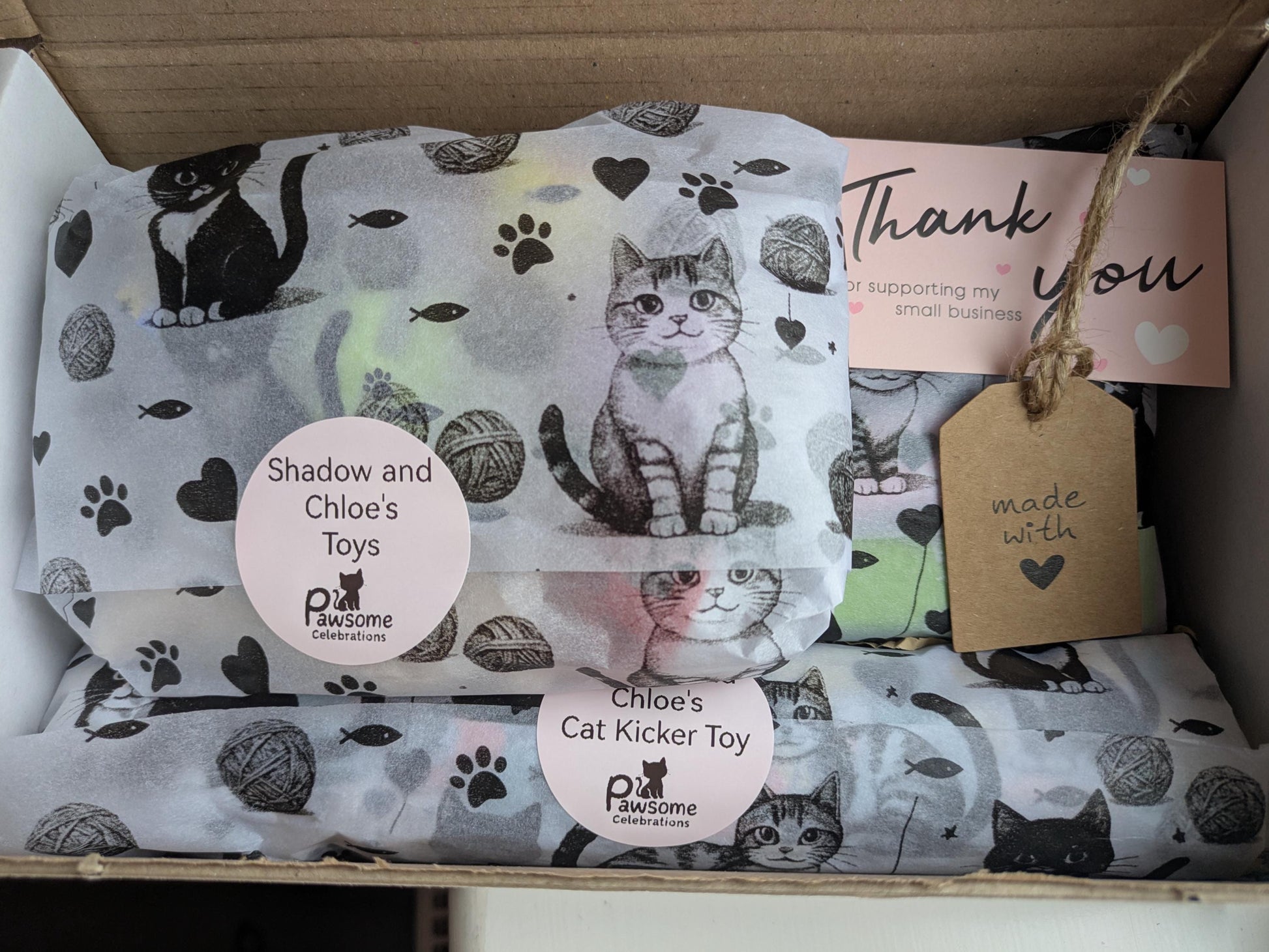 Personalised cat treat box with catnip kicker toy, paw print wrapping, and thank you tag.