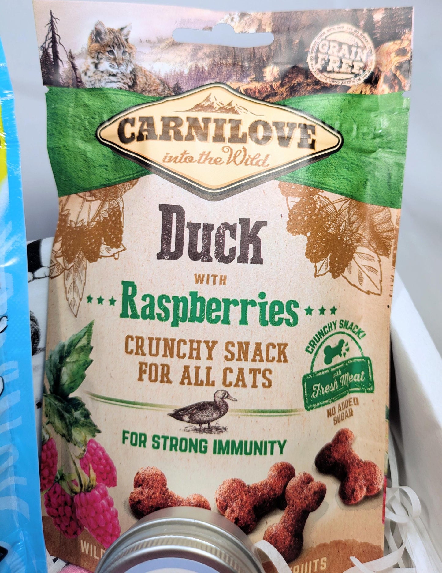 Carnilove Duck with Raspberries crunchy cat treats bag with natural ingredient graphics.