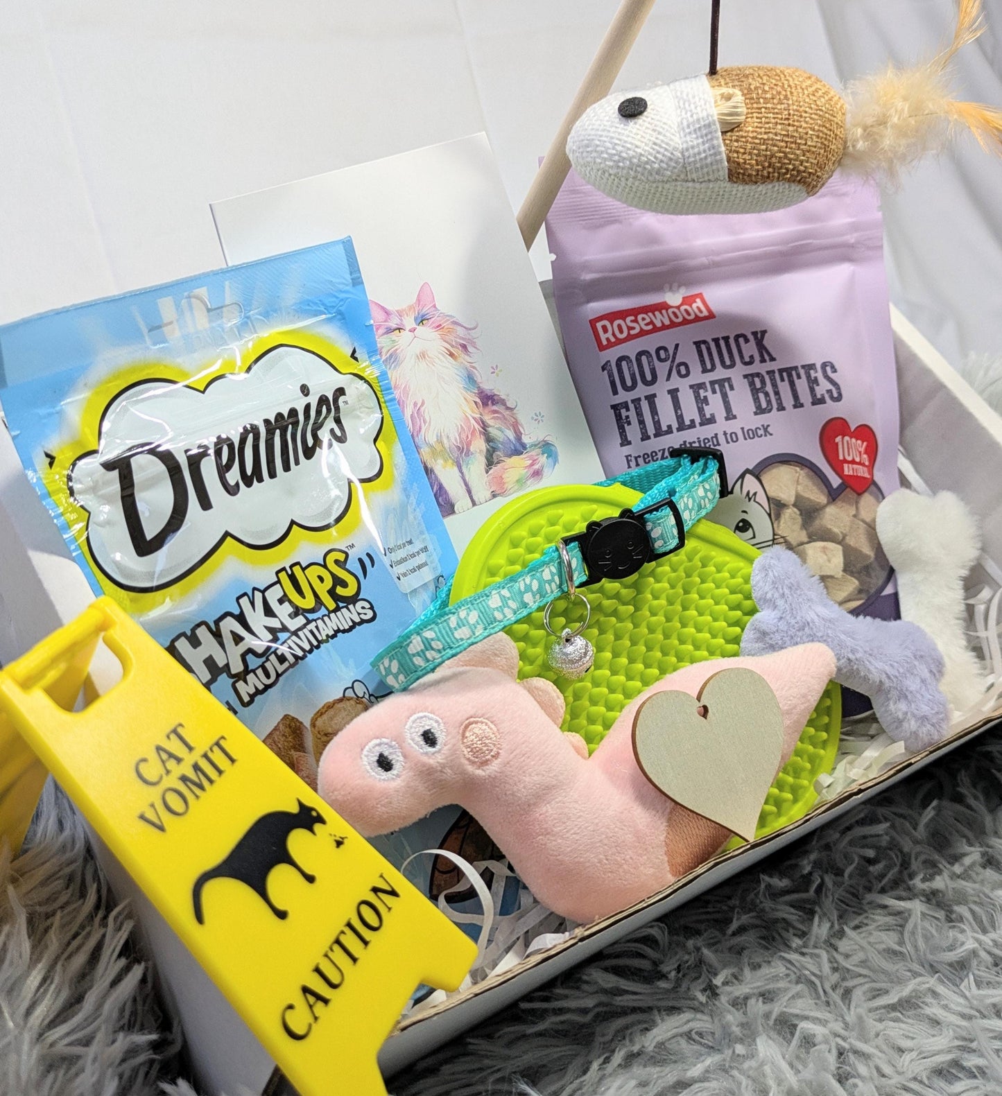 Luxury cat gift box with toys, duck fillet treats, pink plush mouse, green collar, and caution sign tag.