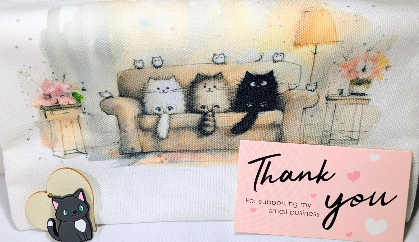 Gift box with cat-themed mug, a thank you card, and illustrated cat artwork on soft fabric background.