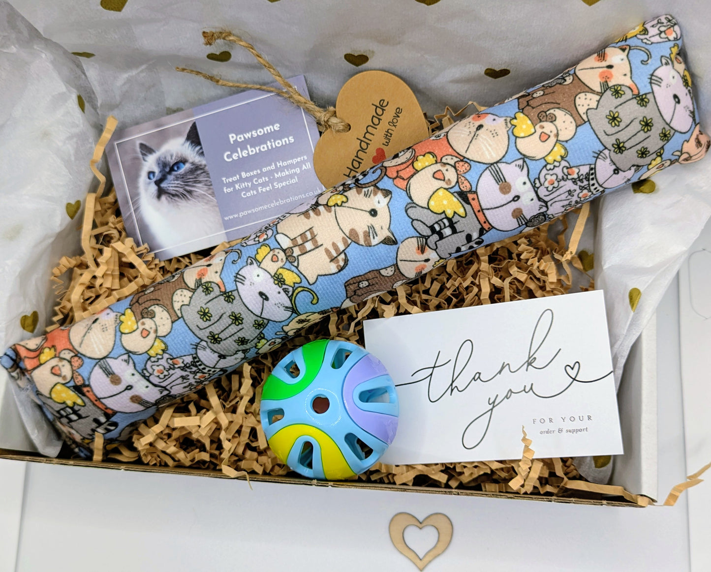 Cat-themed gift box with a colorful catnip toy, card, and other items.