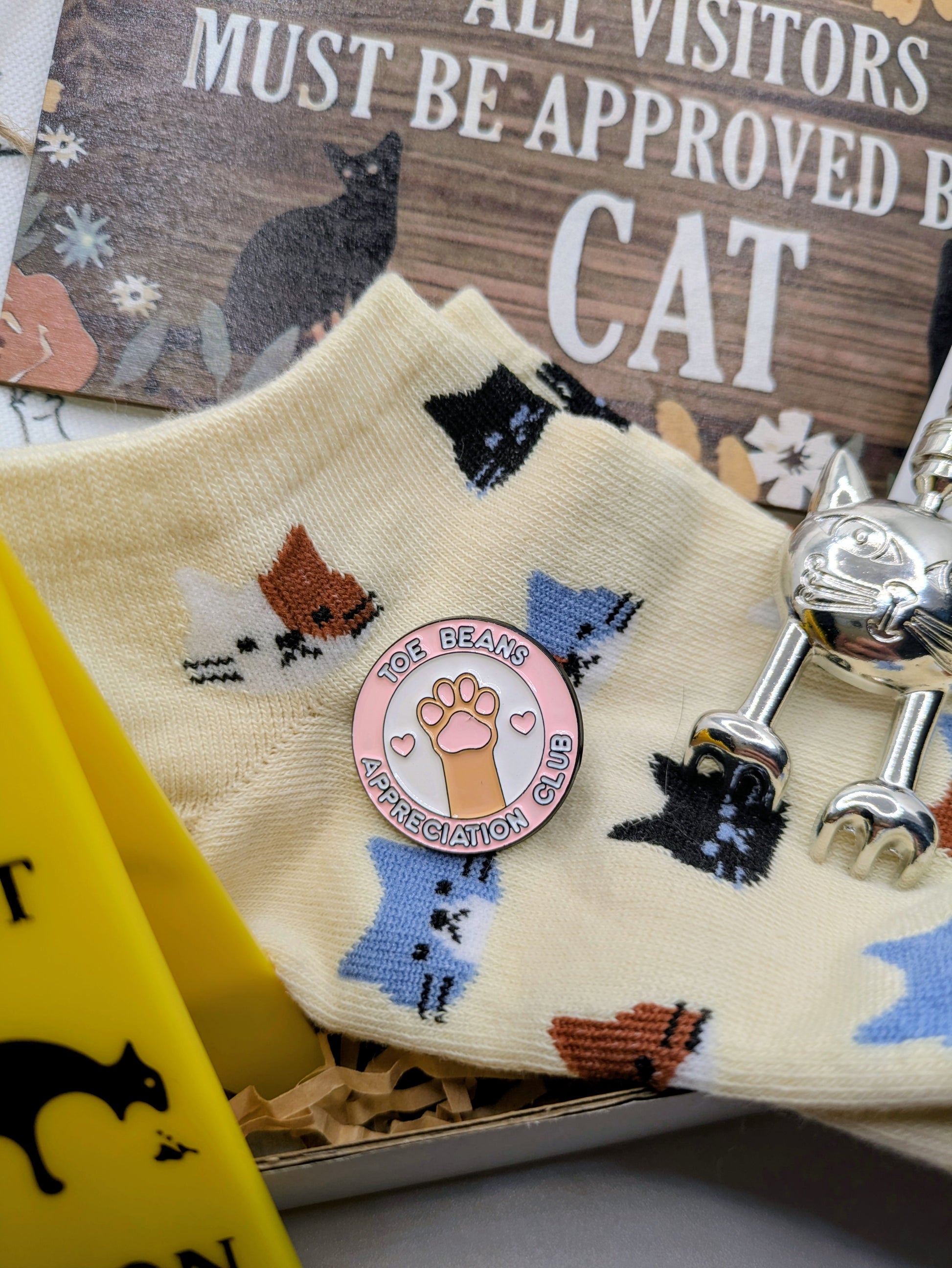 Enamel pink toe bean appreciation club pin, socks, back scratcher, in a cat themed gift set.