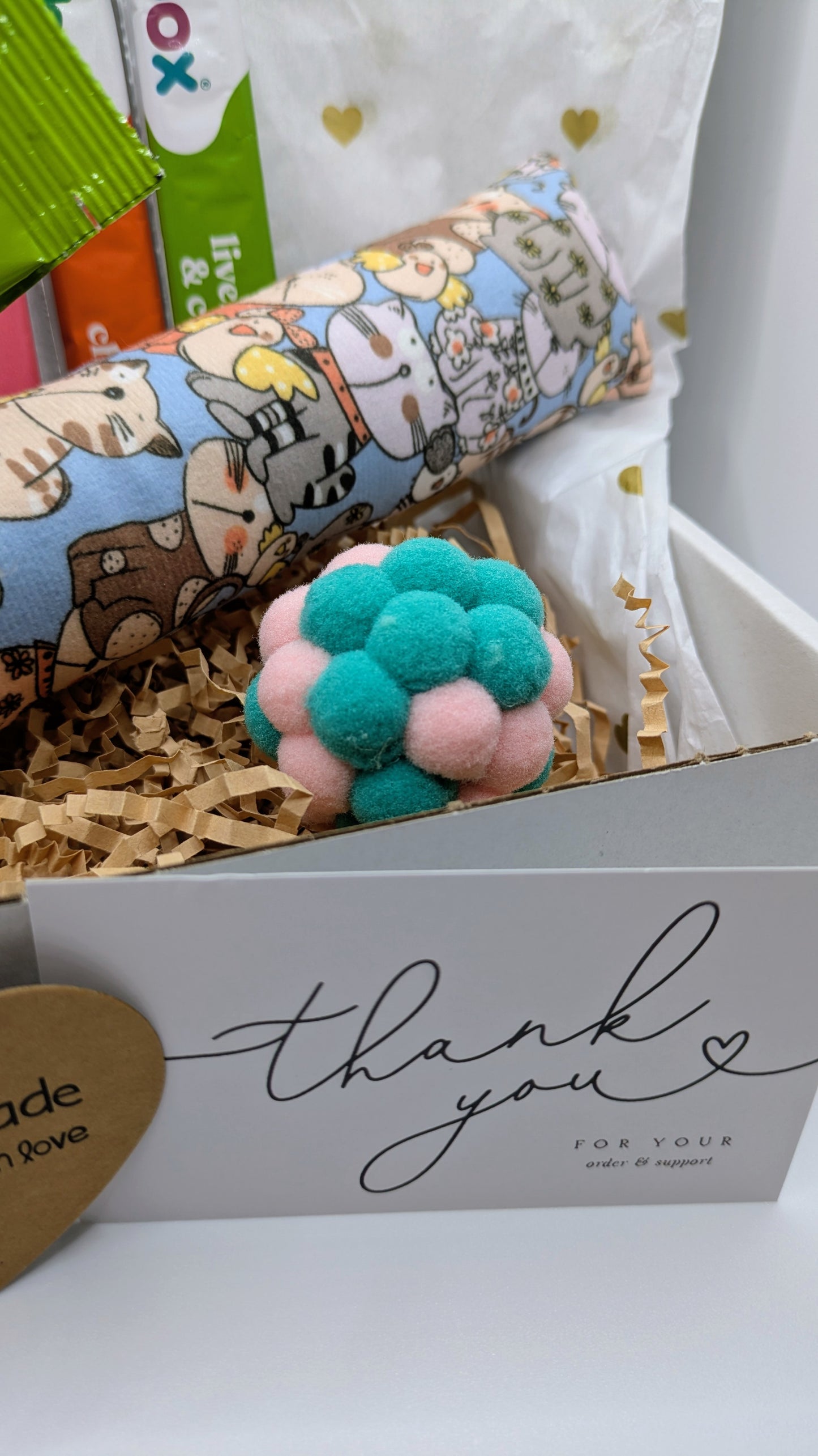 Gift box with a plush toy, card, and decorative item on a white background