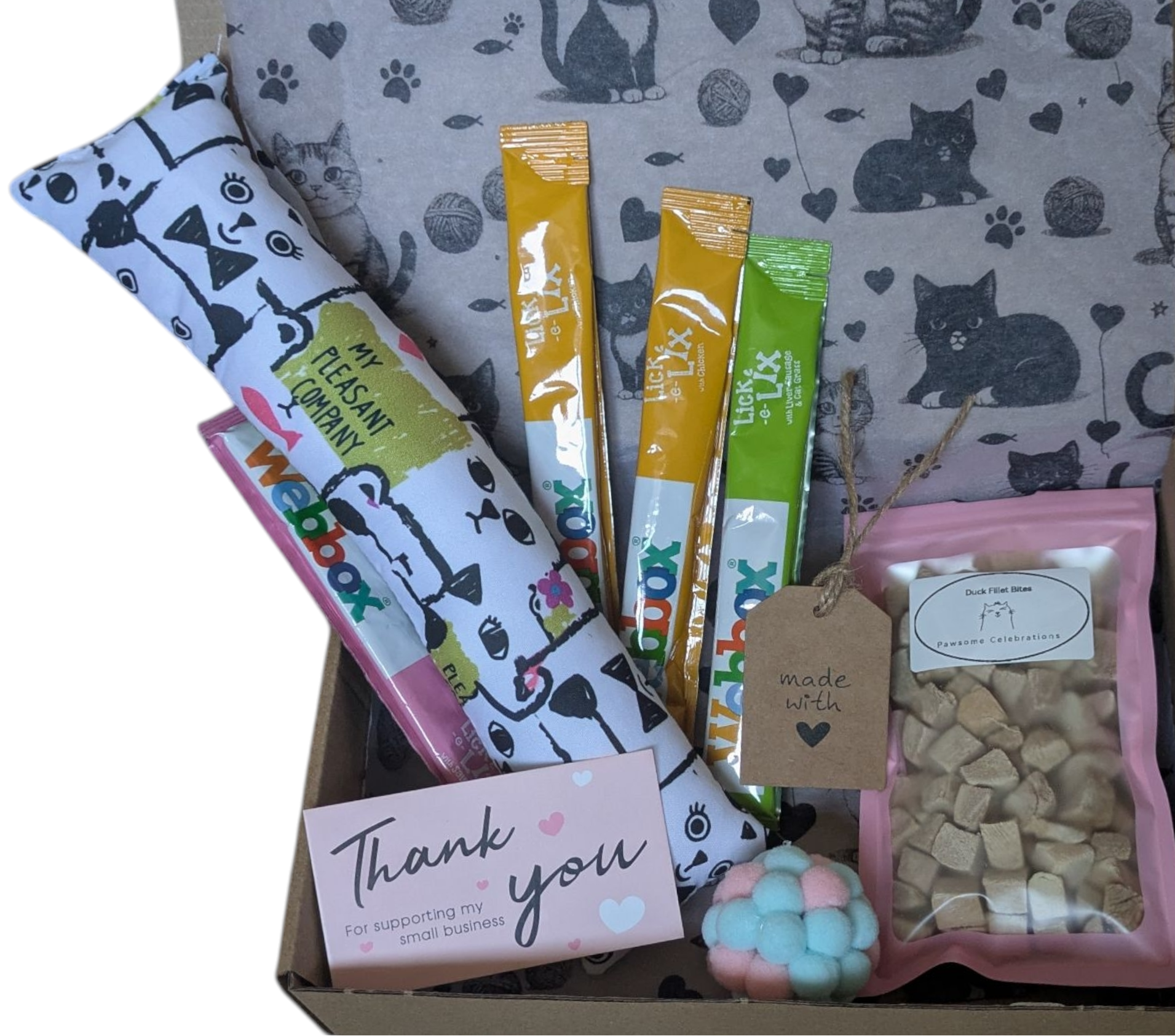 Cat-themed gift box with various cat products including a blanket, treats, and a card.