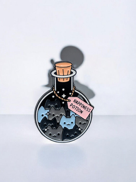 Enamel pin of a potion bottle labeled 'Happiness Potion' and it is filled with cats, on a white background