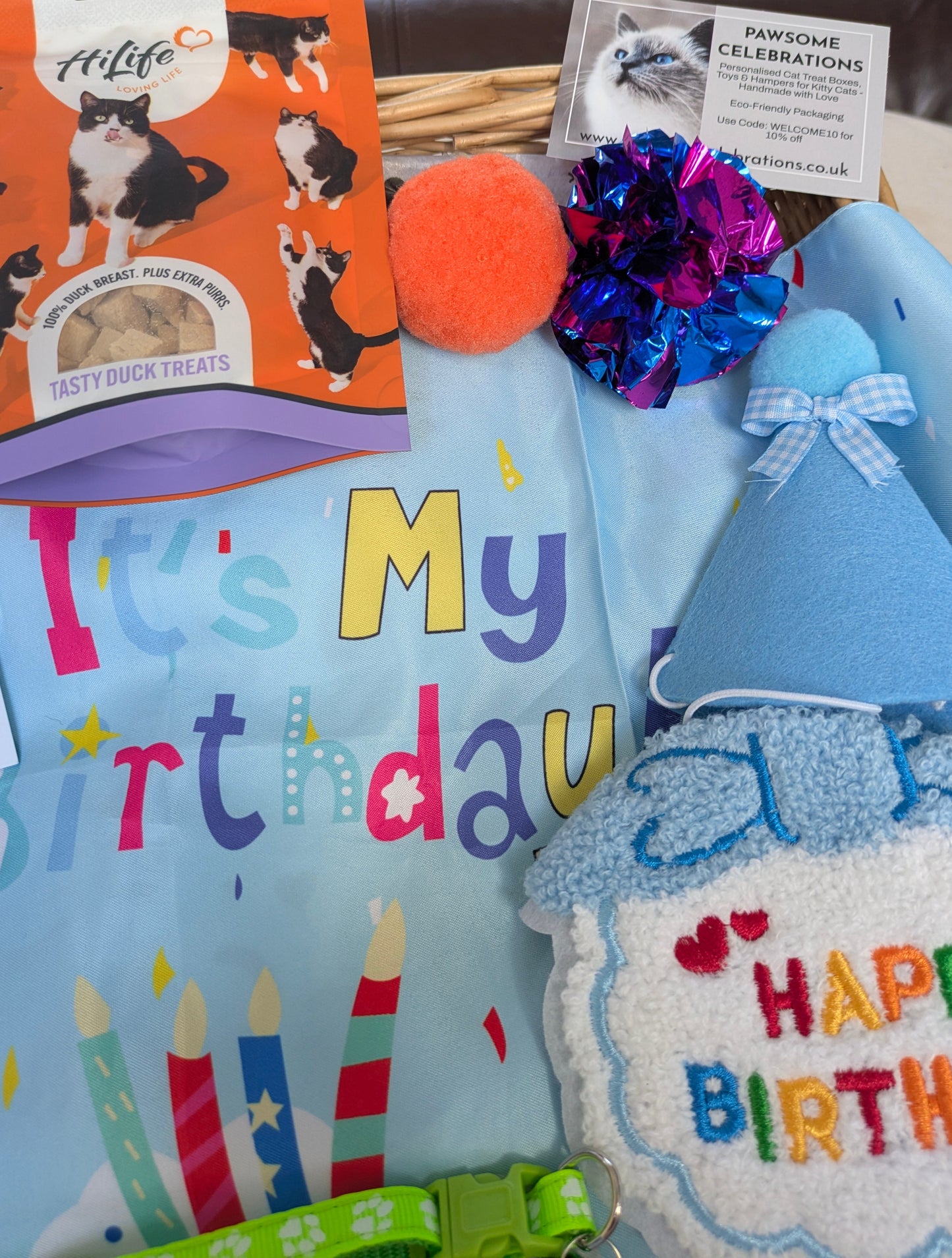 Collection of birthday-themed cat products including a card, treats, and toys.