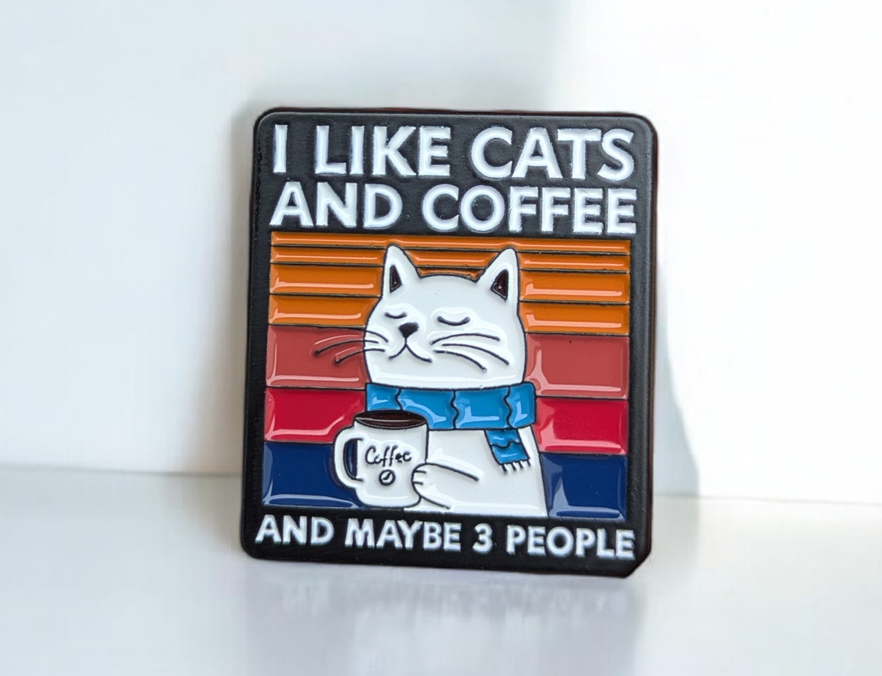 Enamel Pin with a cat illustration and text 'I like cats and coffee and maybe 3 people' on a white background