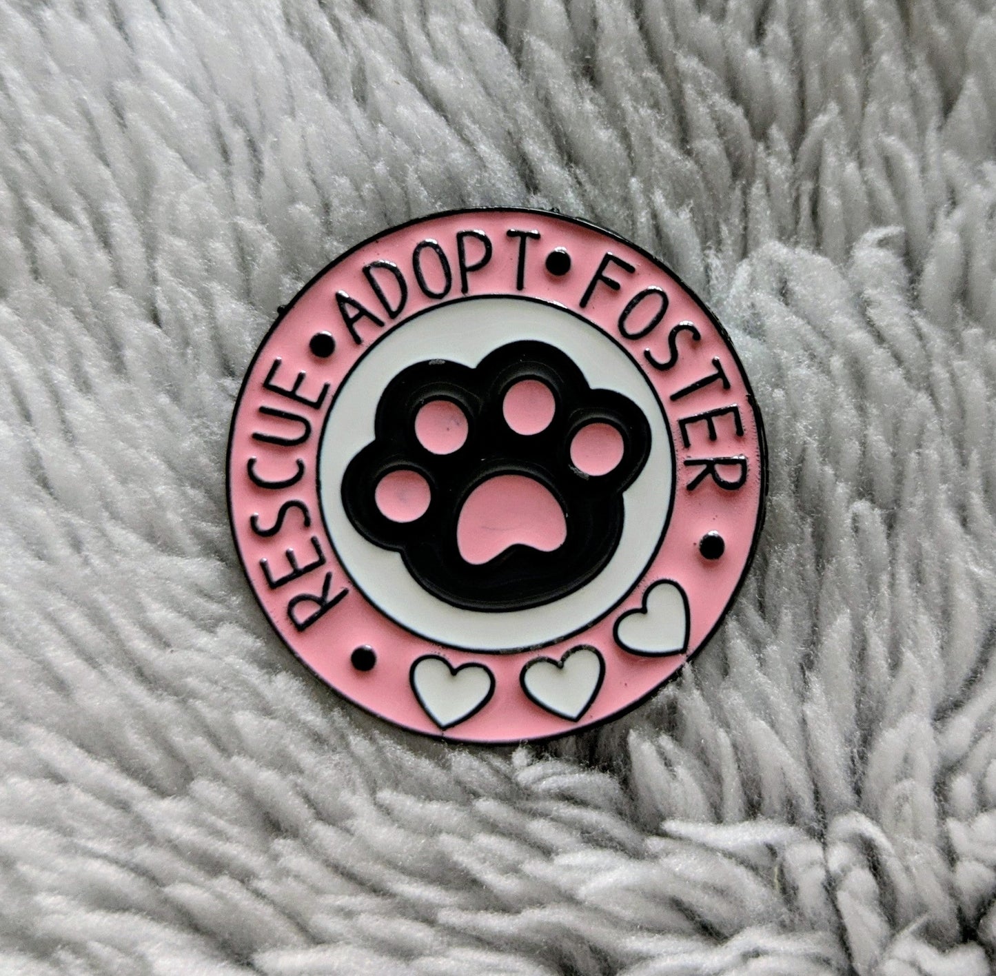 RESCUE ADOPT FOSTER Enamel Pin badge with pink border, white love hearts and black paw and pin back lapel