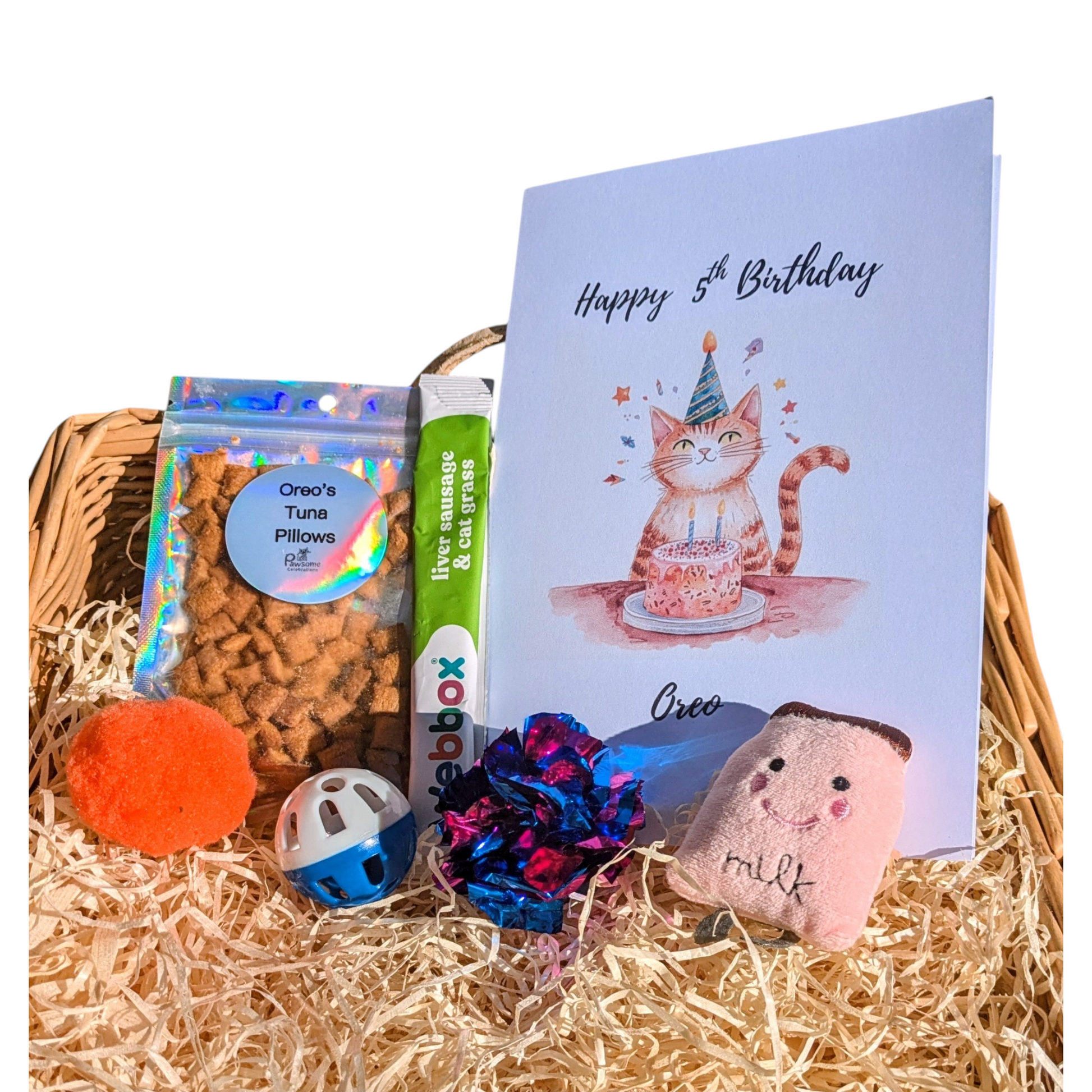 Gift basket with pet toys, treats, and a birthday card on a white background