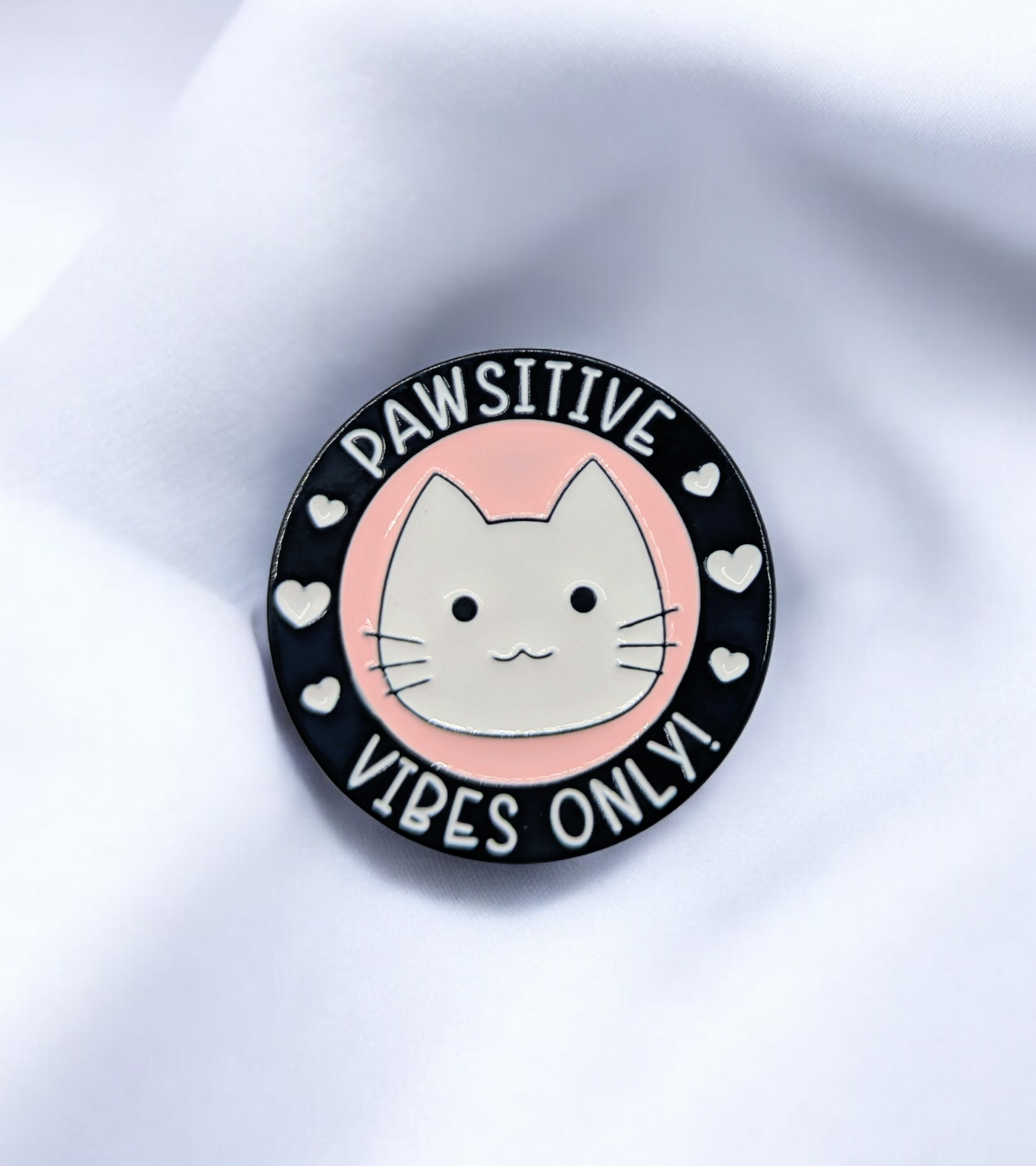Circular enamel pin lapel badge with a cat illustration and text 'PAWSITIVE VIBES ONLY!' on a white background